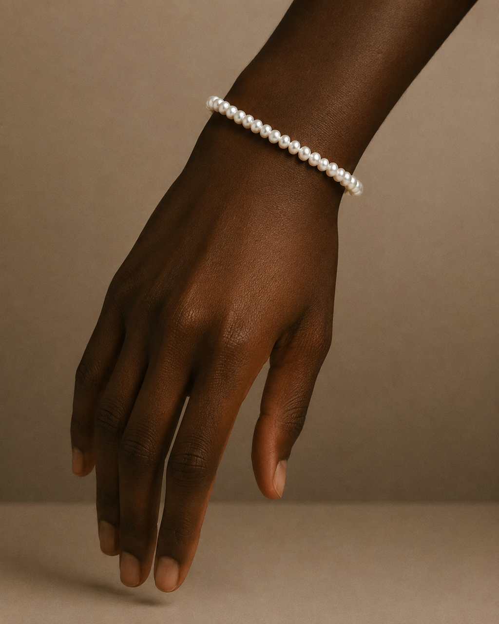 A close-up of a person's wrist wearing a Lulu Bracelet by Ryã Atelier featuring petite 4mm freshwater pearls with sterling silver clasp. 