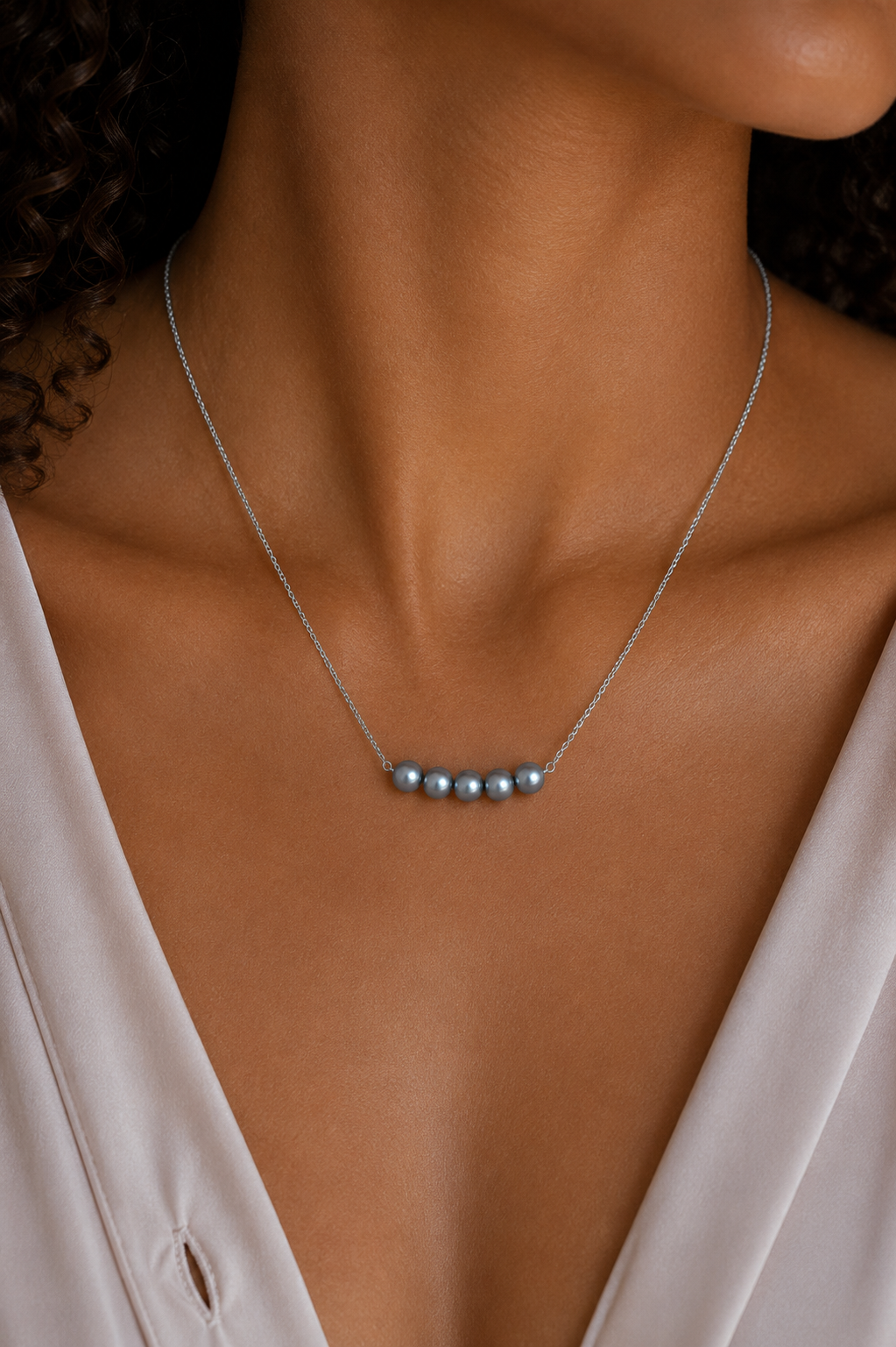 Model Wearing The Vivienne Necklace by Ryā Atelier featuring 5 blue-toned freshwater pearls on a delicate sterling silver belcher chain. 