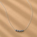The Vivienne Necklace by Ryā Atelier featuring 5 blue-toned freshwater pearls on a delicate sterling silver belcher chain. 