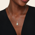 A close-up of a model wearing the large Inyembezi pendant featuring a 23mm teardrop-shaped Mabe pearl in a solid stelring silver bezel 