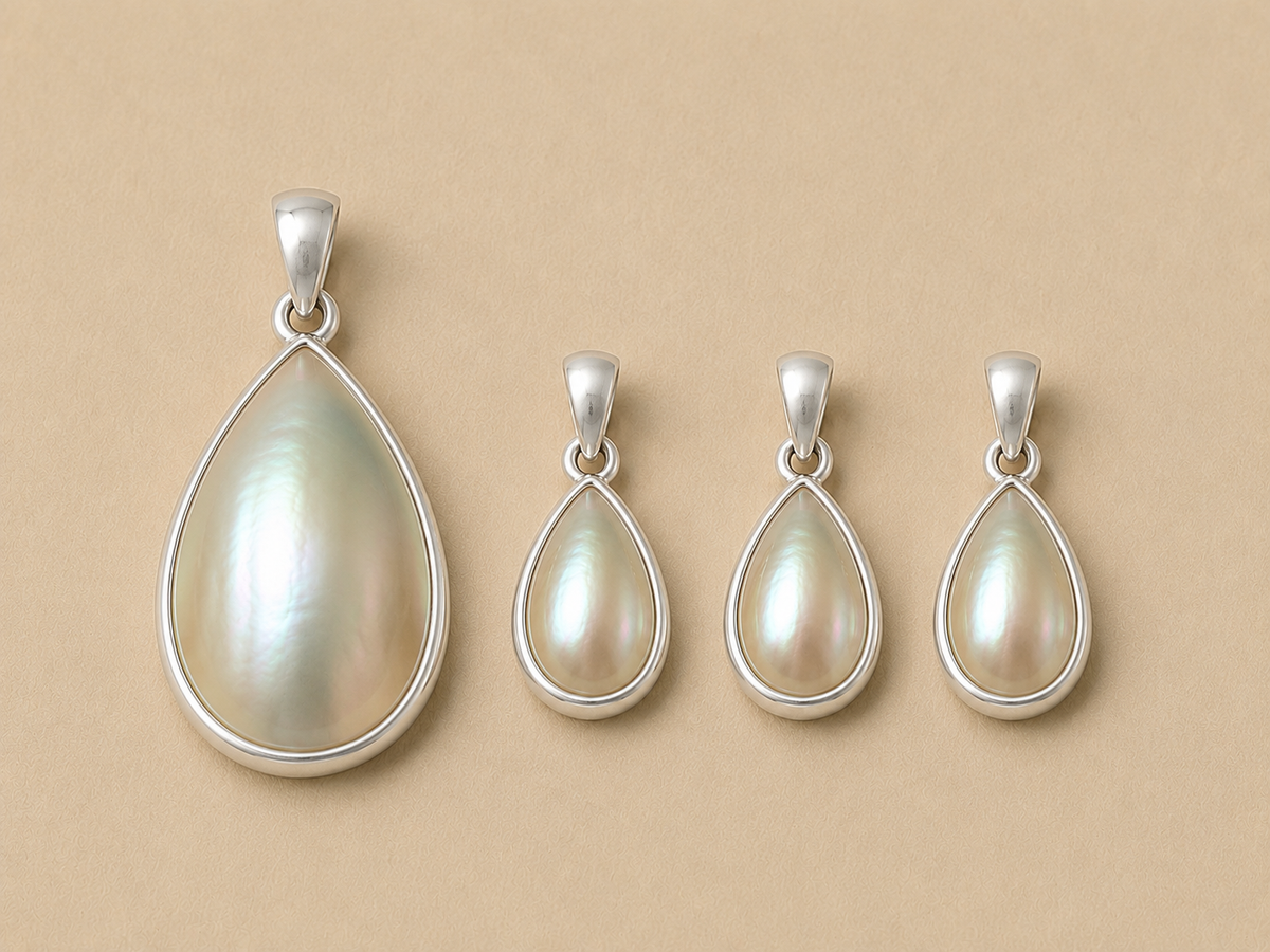The inyembezi pendant from Ryā Atelier features a teardrop-shaped mabe pearl set in a solid sterling silver bezel. available in 2 different sizes 