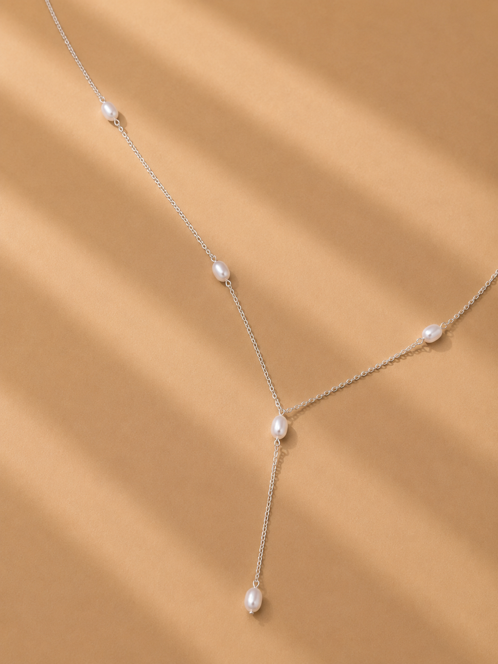 The Ryã Atelier Nubia Necklace with 6mm freshwater pearls spaced along a sterling silver chain and pearl drop