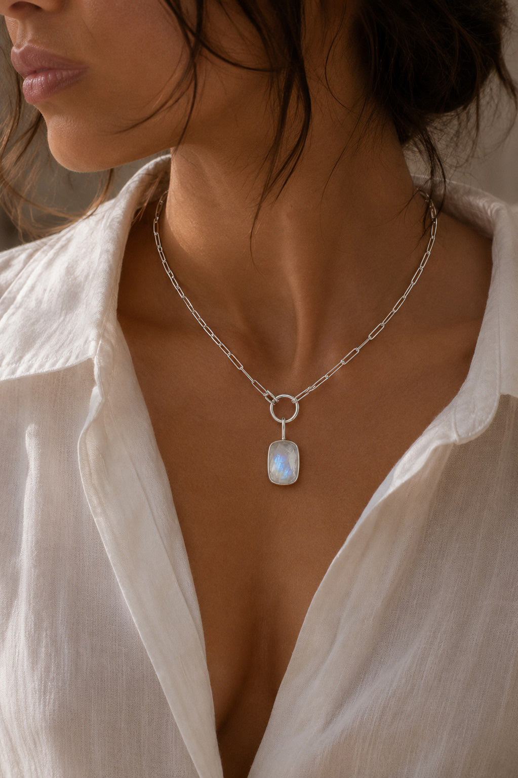 Unyezi Moonstone Stadium Pendant by Rya Atelier, handcrafted in sterling silver featuring a natural one-of-a-kind Moonstone on a model. 