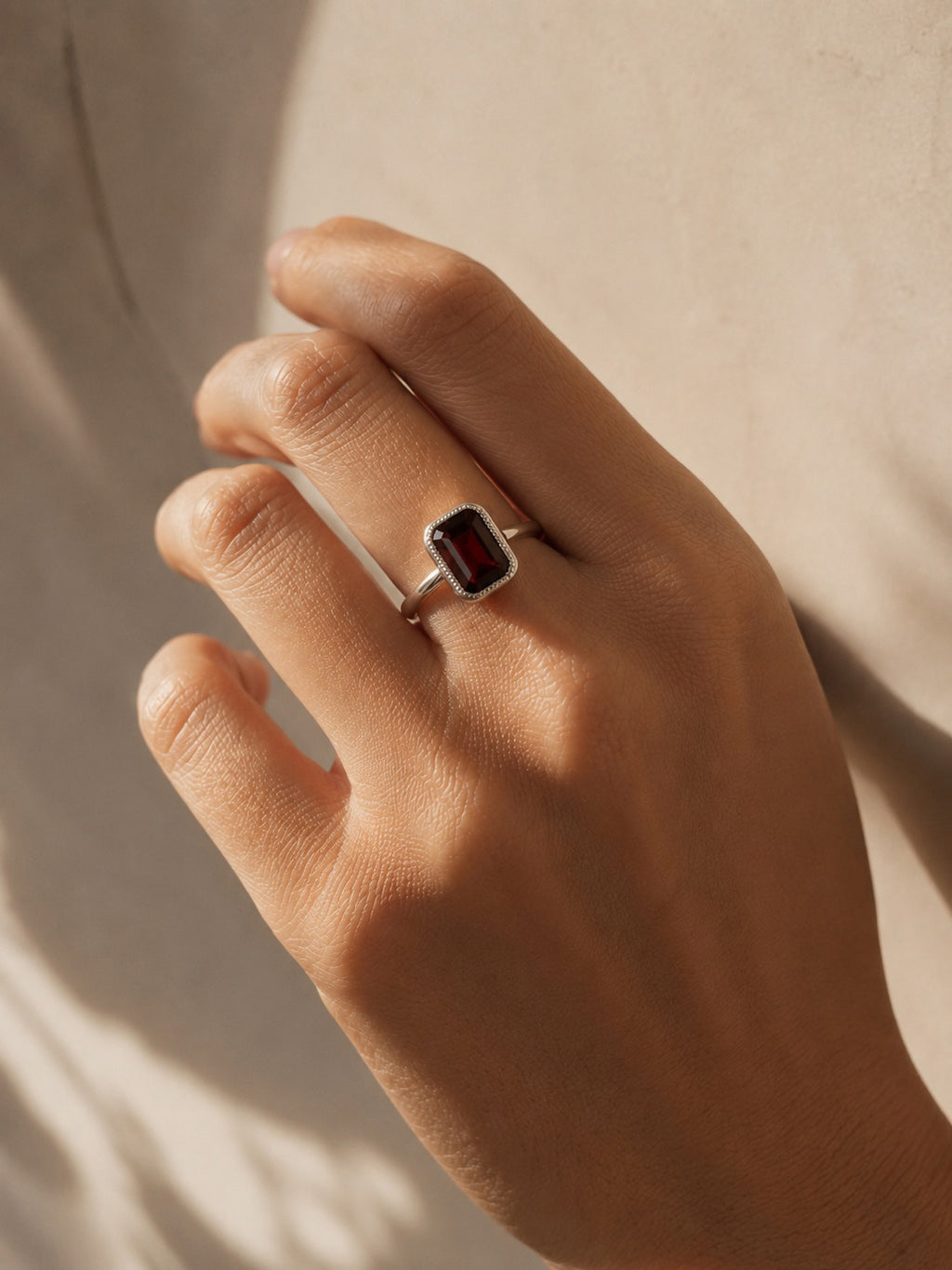 Model wearing the Amahle Ring handcrafted in solid 925 sterling silver with a natural emerald cut garnet by Ryã Atelier.