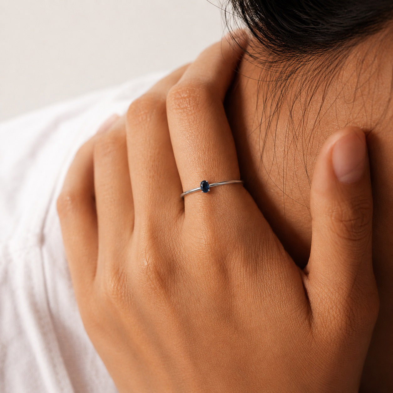 Model wearing the Amani solitaire Ring handcrafted in solid 925 sterling silver with a natural oval sapphire by Ryã Atelier.