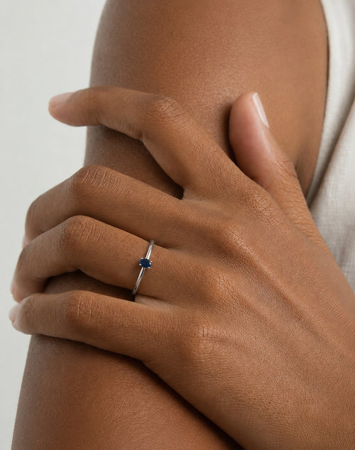 Hand model wearing the Amani Solitaire Ring handcrafted in solid 925 sterling silver with a natural oval sapphire by Ryã Atelier on her ring finger.