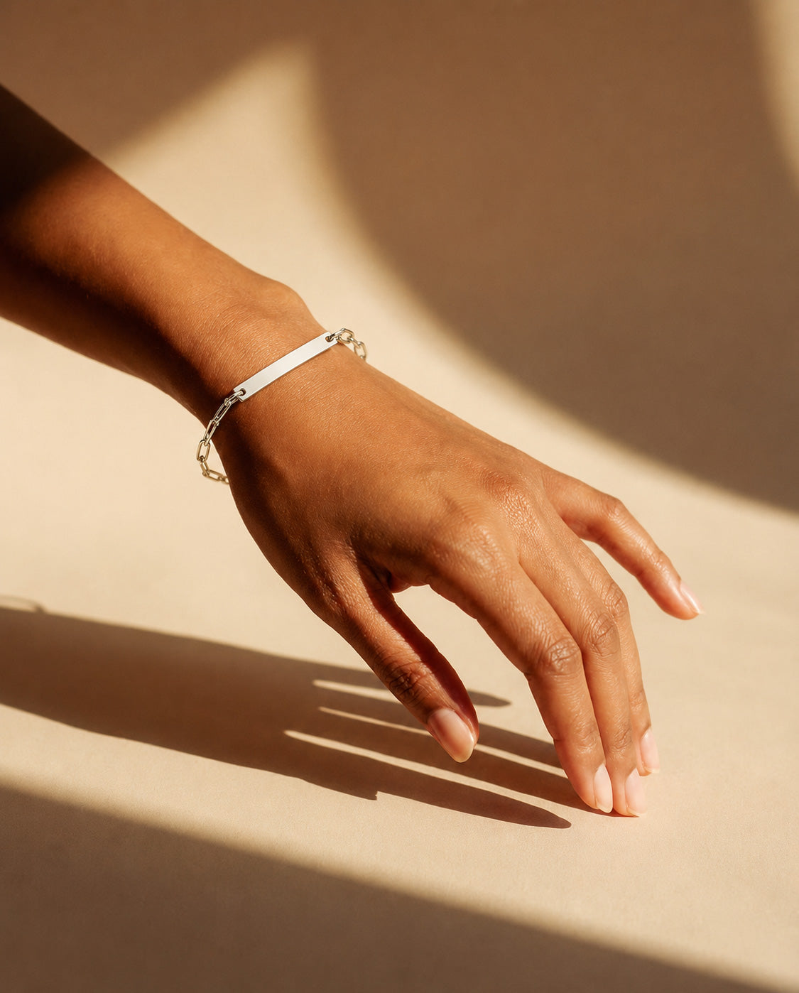 model wearing a handcrafted Solid 925 sterling silver paperclip bracelet with engraving plate by Ryā Atelier.