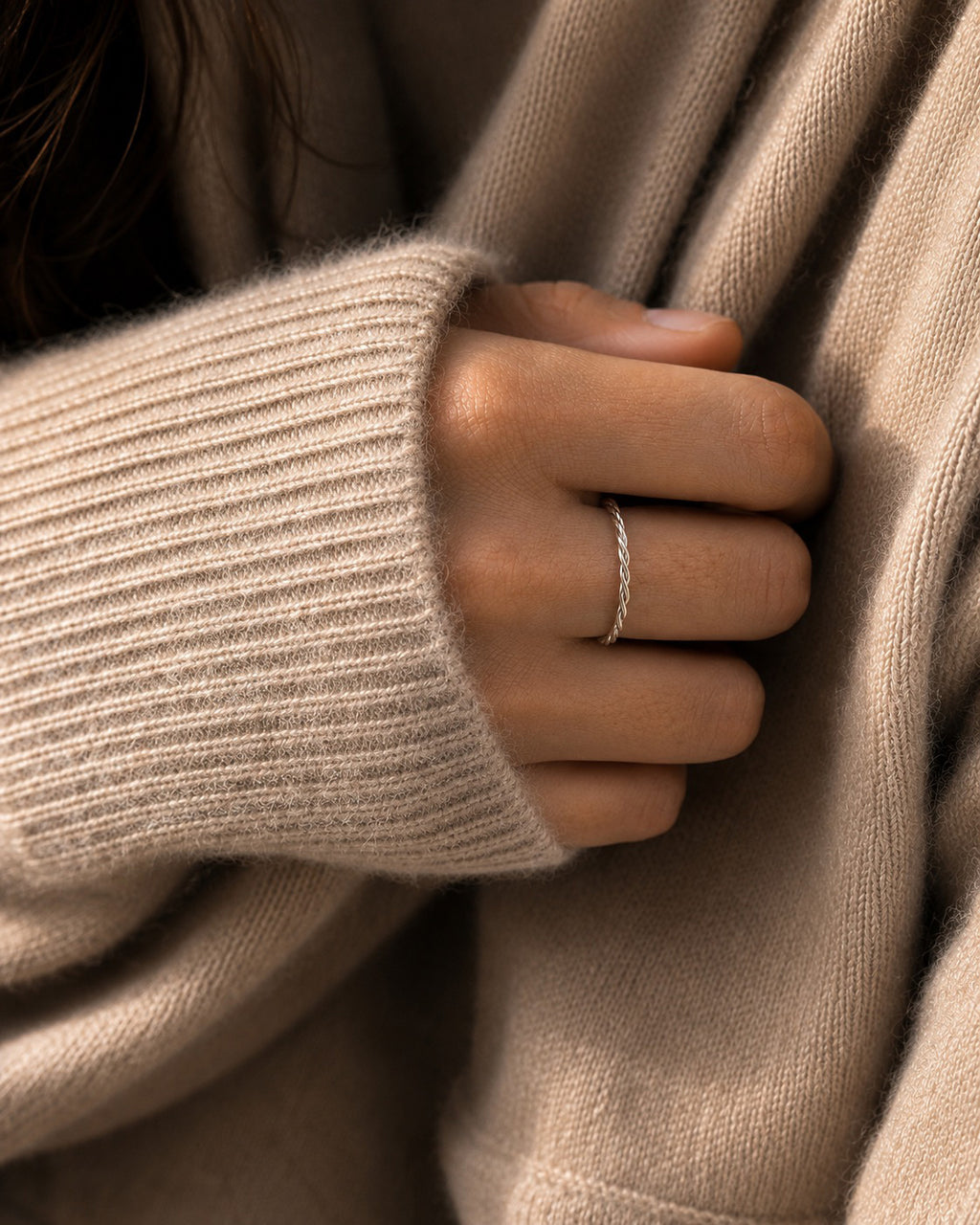 Close-up of a hand wearing the Bella Twisted Ring handcrafted in solid 925 sterling silver, design by Ryã Atelier.