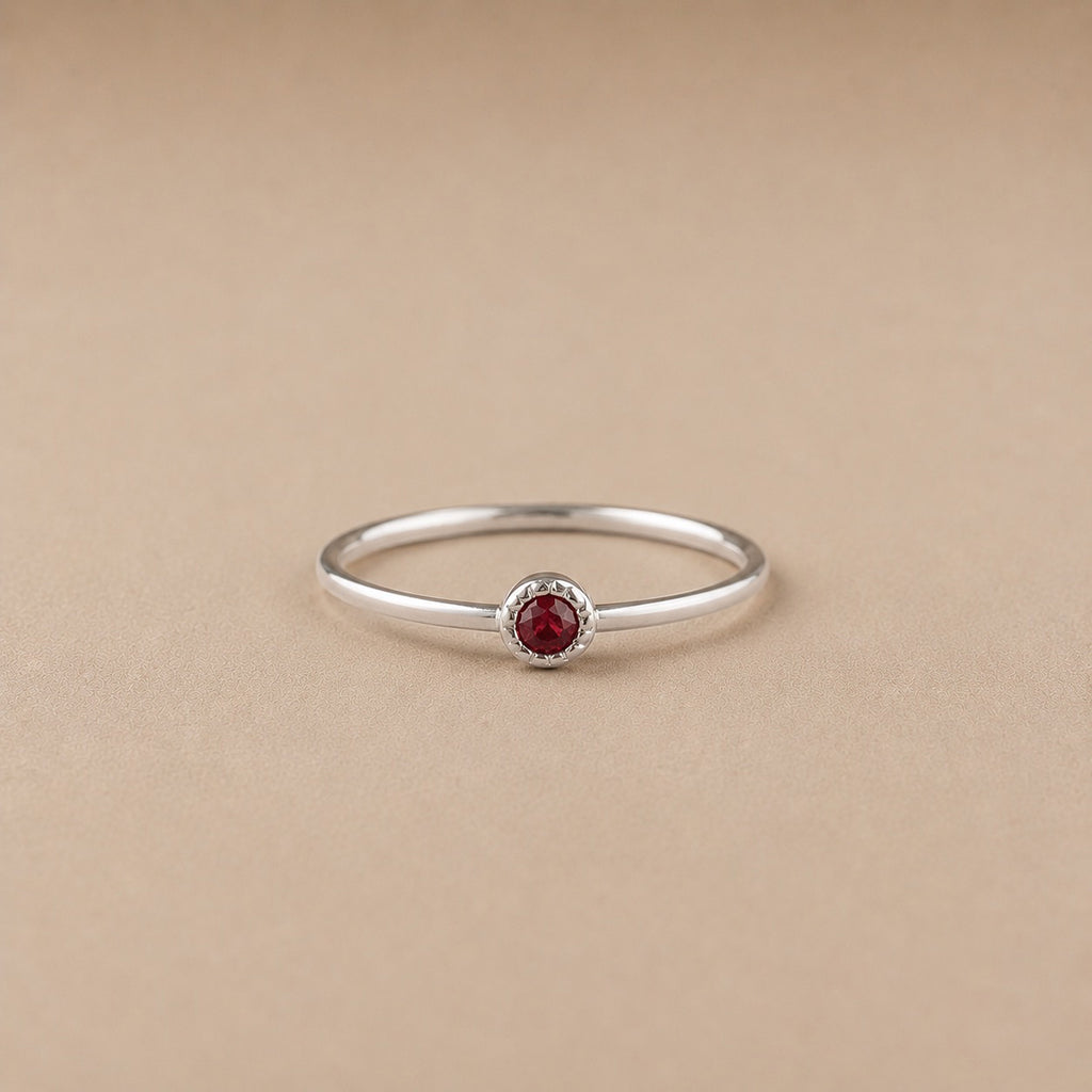 Sterling Silver ring with a natural ruby gem on a beige background