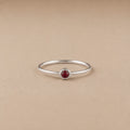 Sterling Silver ring with a natural ruby gem on a beige background