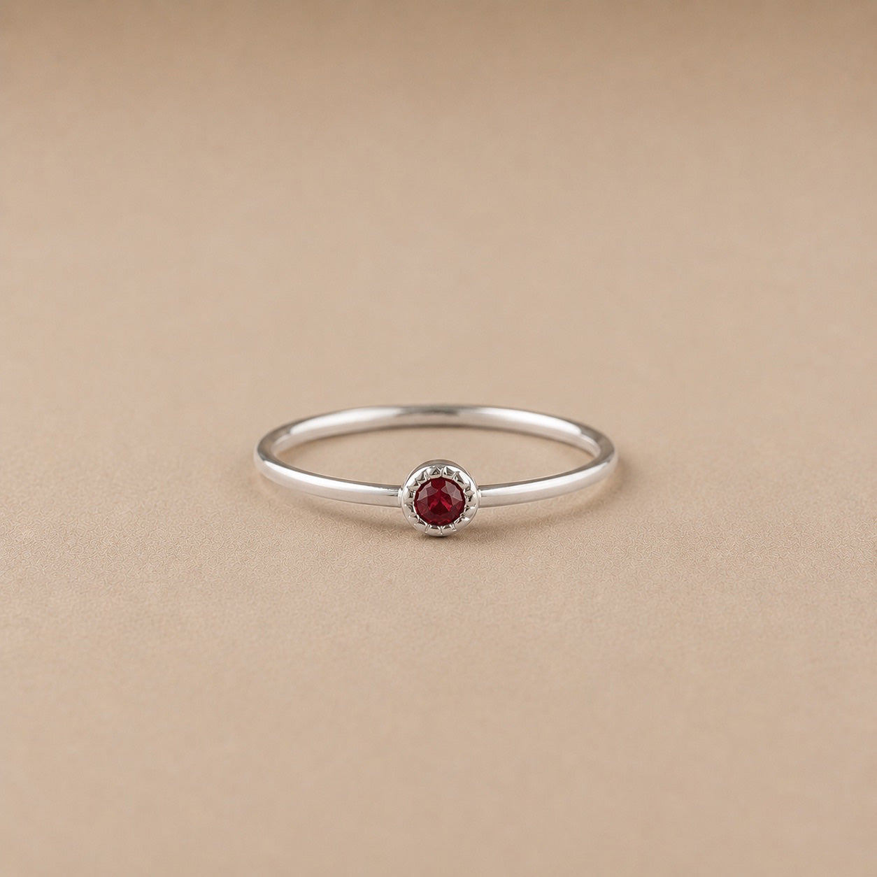 Sterling Silver ring with a natural ruby gem on a beige background