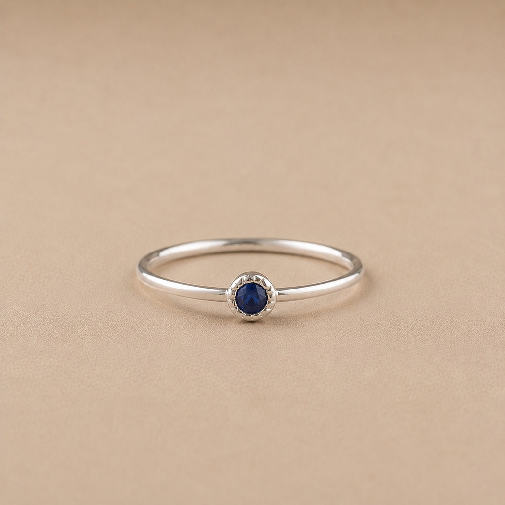 Sterling Silver ring with a natural sapphire gem on a beige background