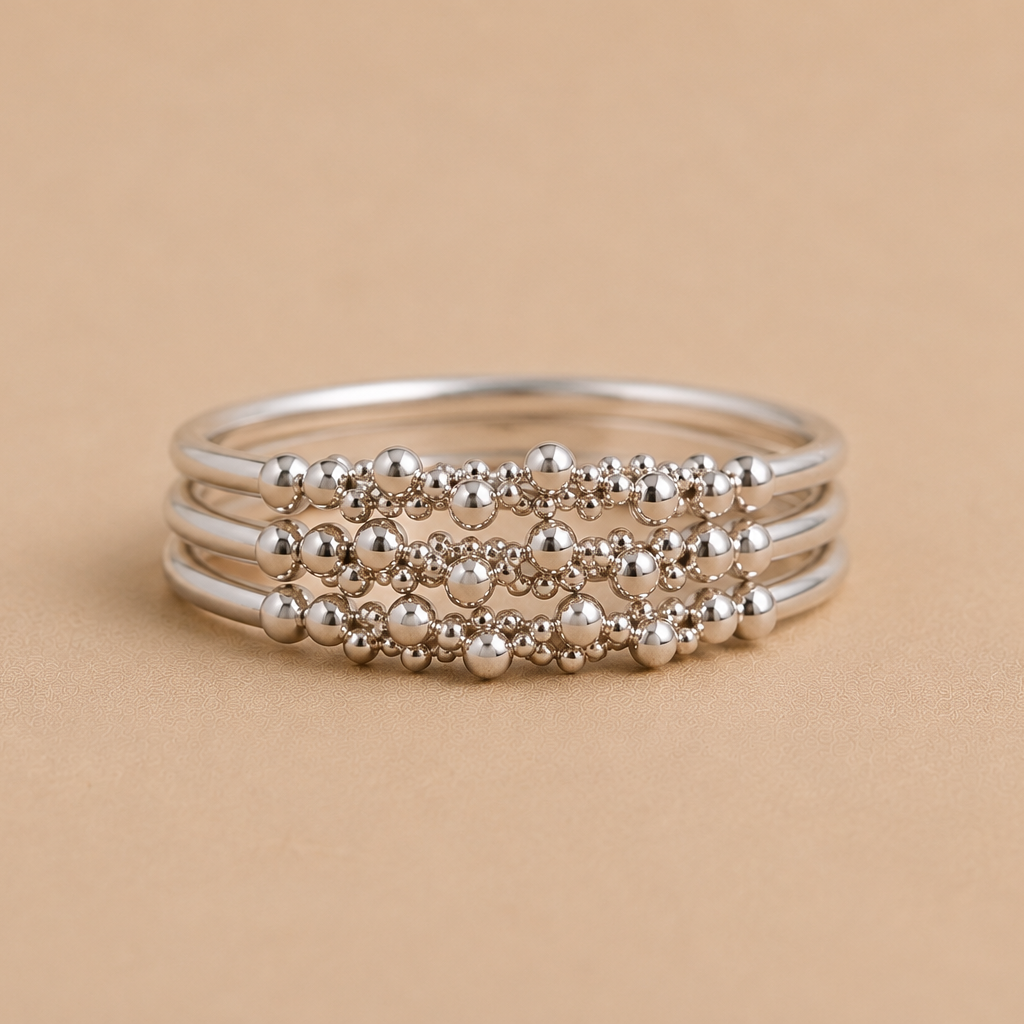 Stack of 3 sterling silver beaded rings on a beige background