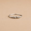 Sterling Silver ring with organic raindrop bead detailing on a beige background