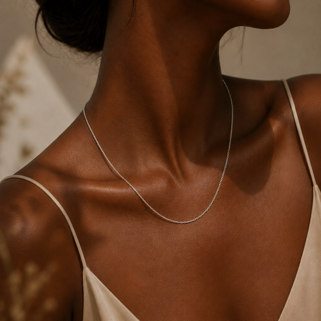 Close-up of a person wearing a delicate 925 sterling silver belcher chain necklace against a neutral background