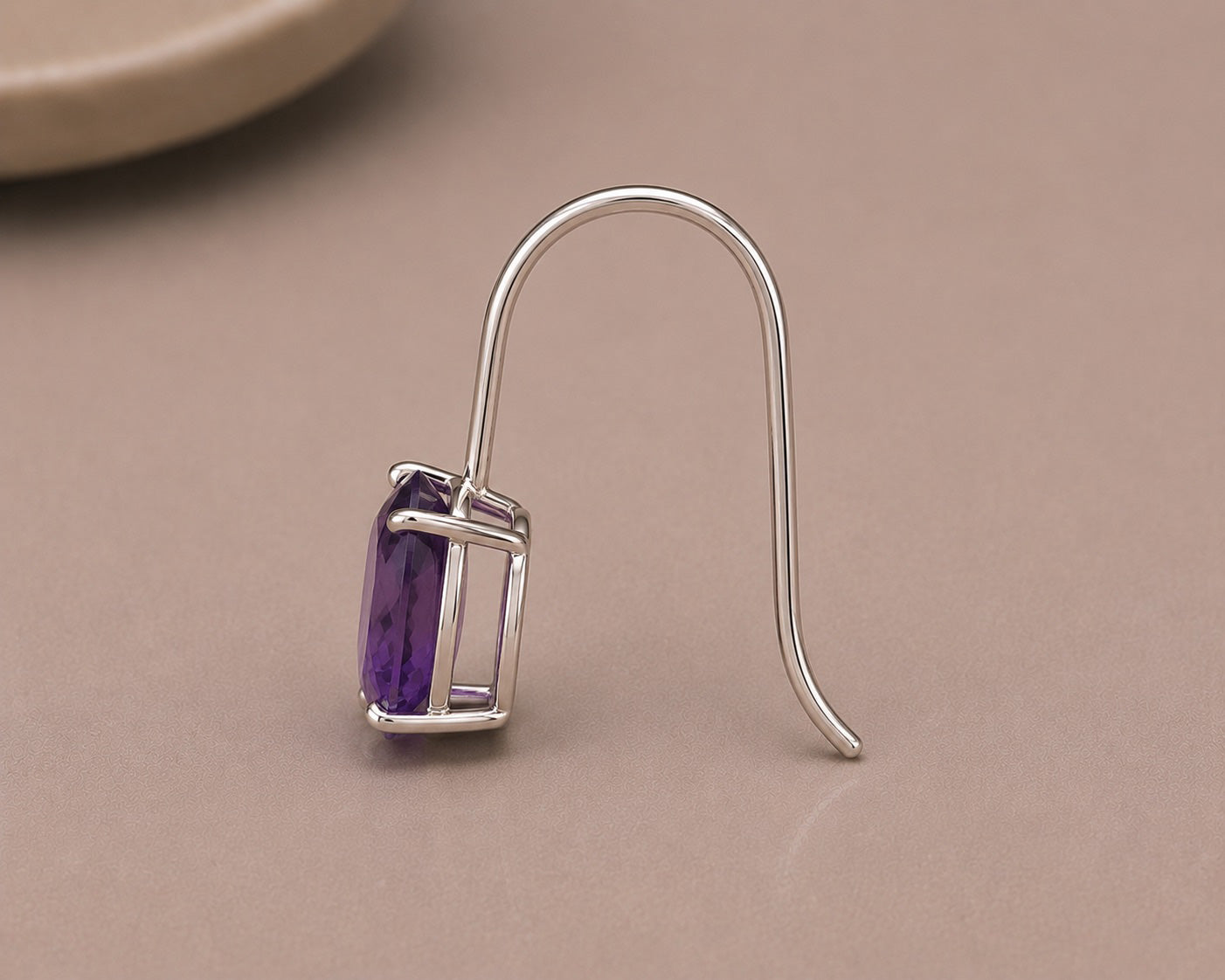 Sterling Silver earring with an oval  amethyst  gemstone on a beige background