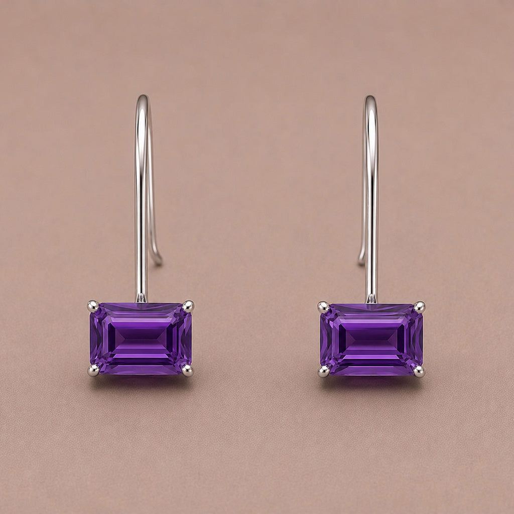 Pair of purple rectangular amethyst drop earrings set in sterling silver on a beige background