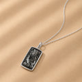 Sterling Silver necklace with a rectangular natural Tourmalated Quartz pendant on a beige background