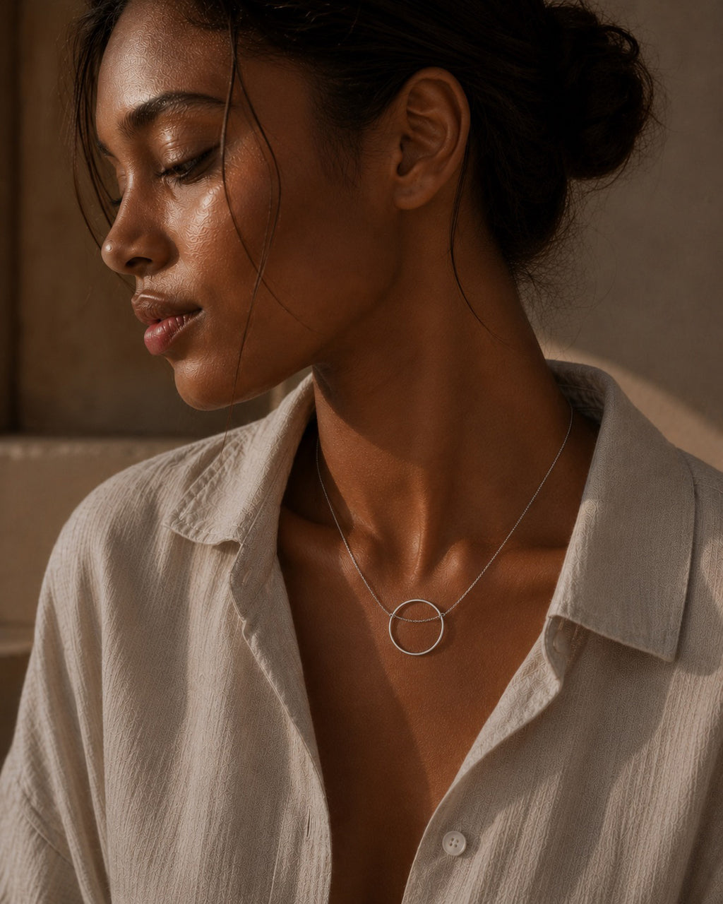 Woman wearing a sterling silver necklace with a minimalistic circular  design