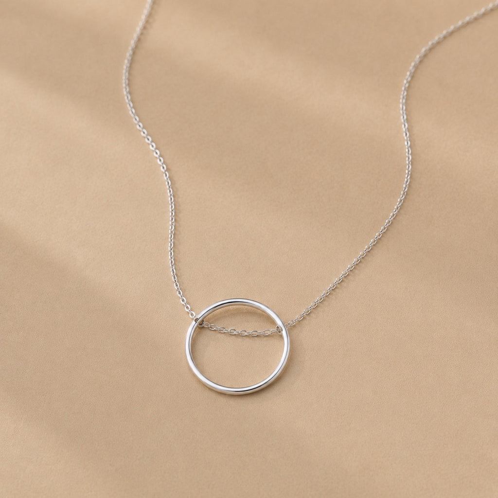 Sterling Silver necklace with a circle pendant on a beige background