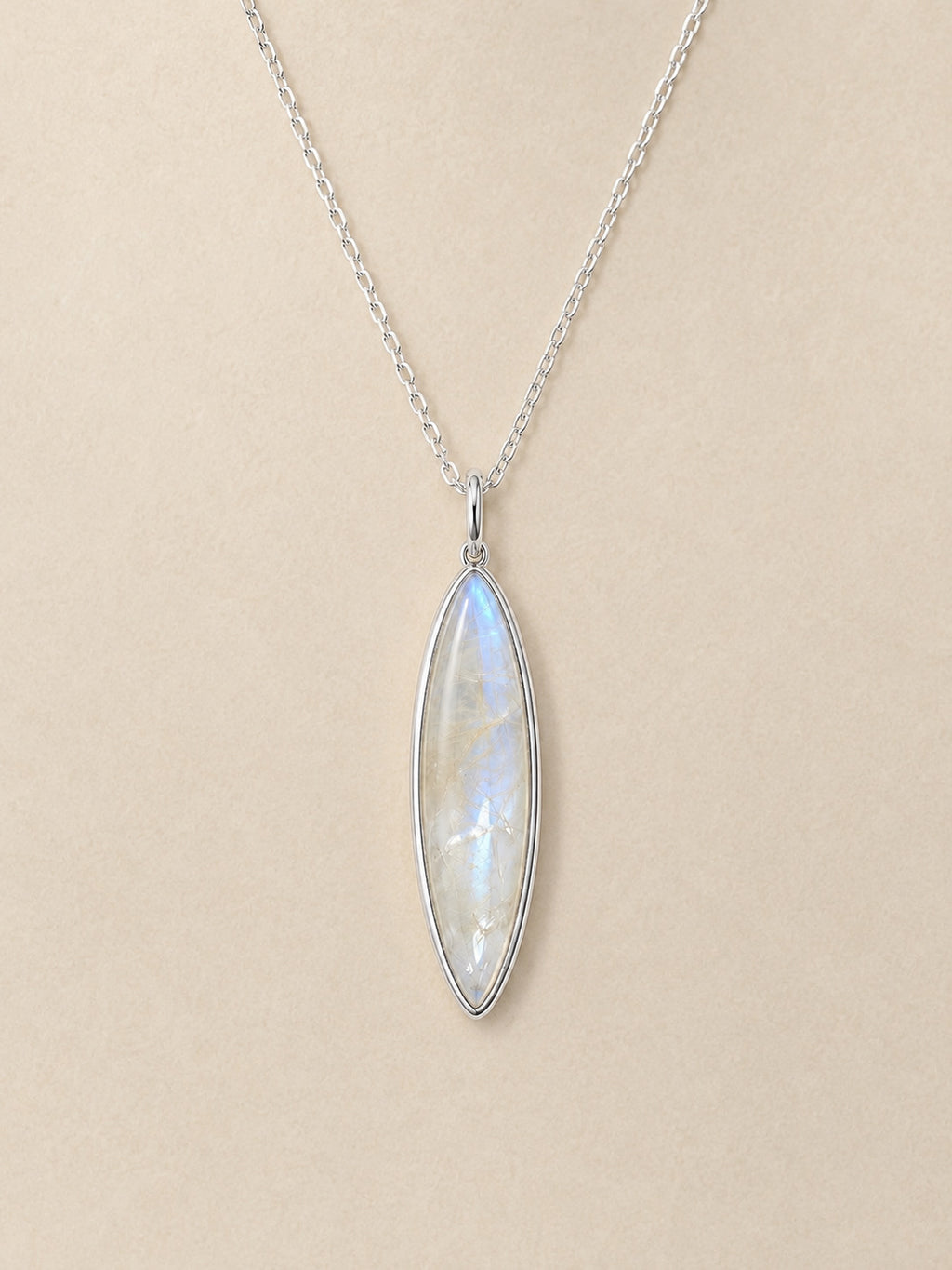 Sterling Silver necklace with a marquise-shaped moonstone pendant on a beige background