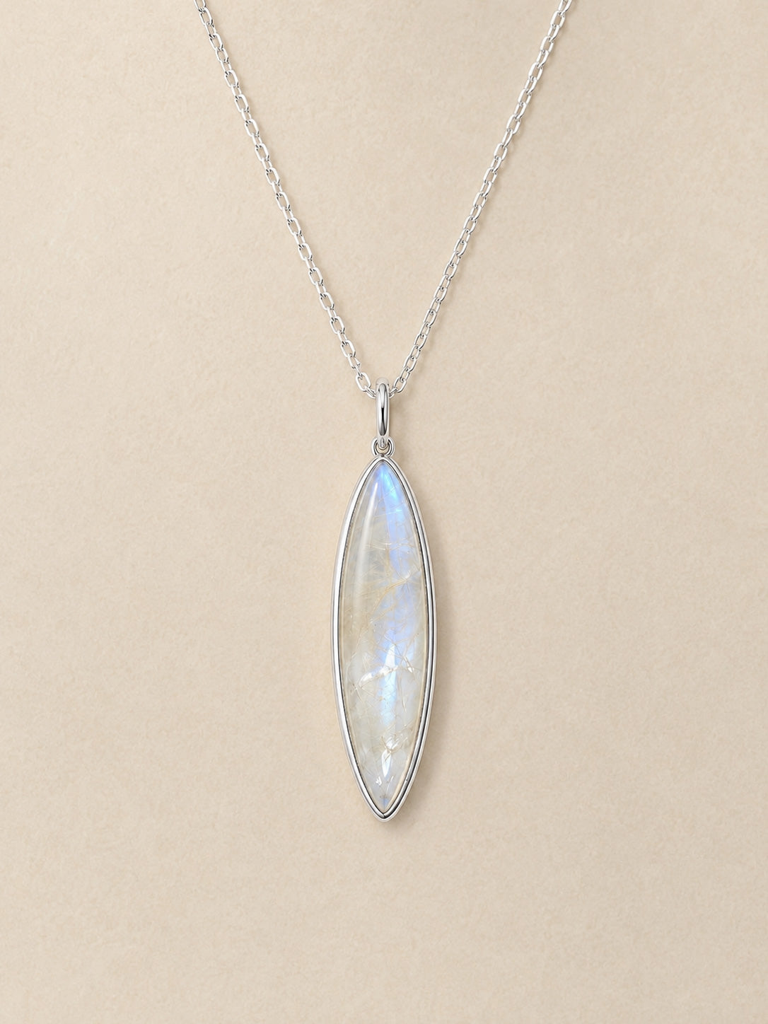 Sterling Silver necklace with a marquise-shaped moonstone pendant on a beige background