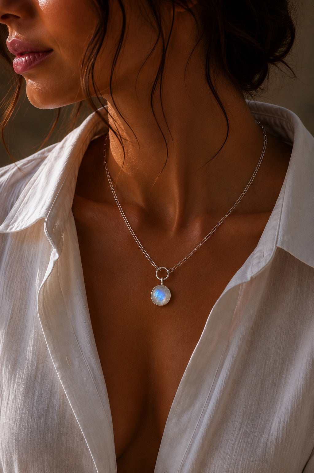 Model wearing the cobble shaped Unyezi Moonstone pendant by Rya Atelier. Faceted Rainbow Moonstone set in solid 925 sterling silver. 