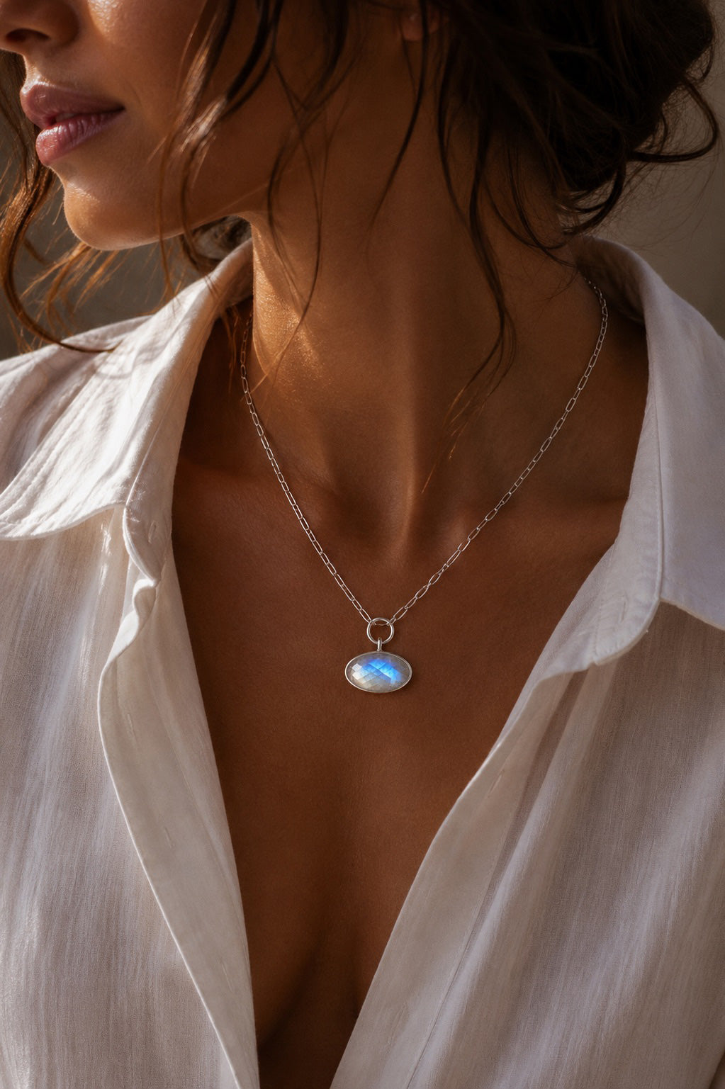 model wearing the elipse shaped Unyezi Moonstone pendant by Rya Atelier. Faceted Rainbow Moonstone set in solid 925 sterling silver. 