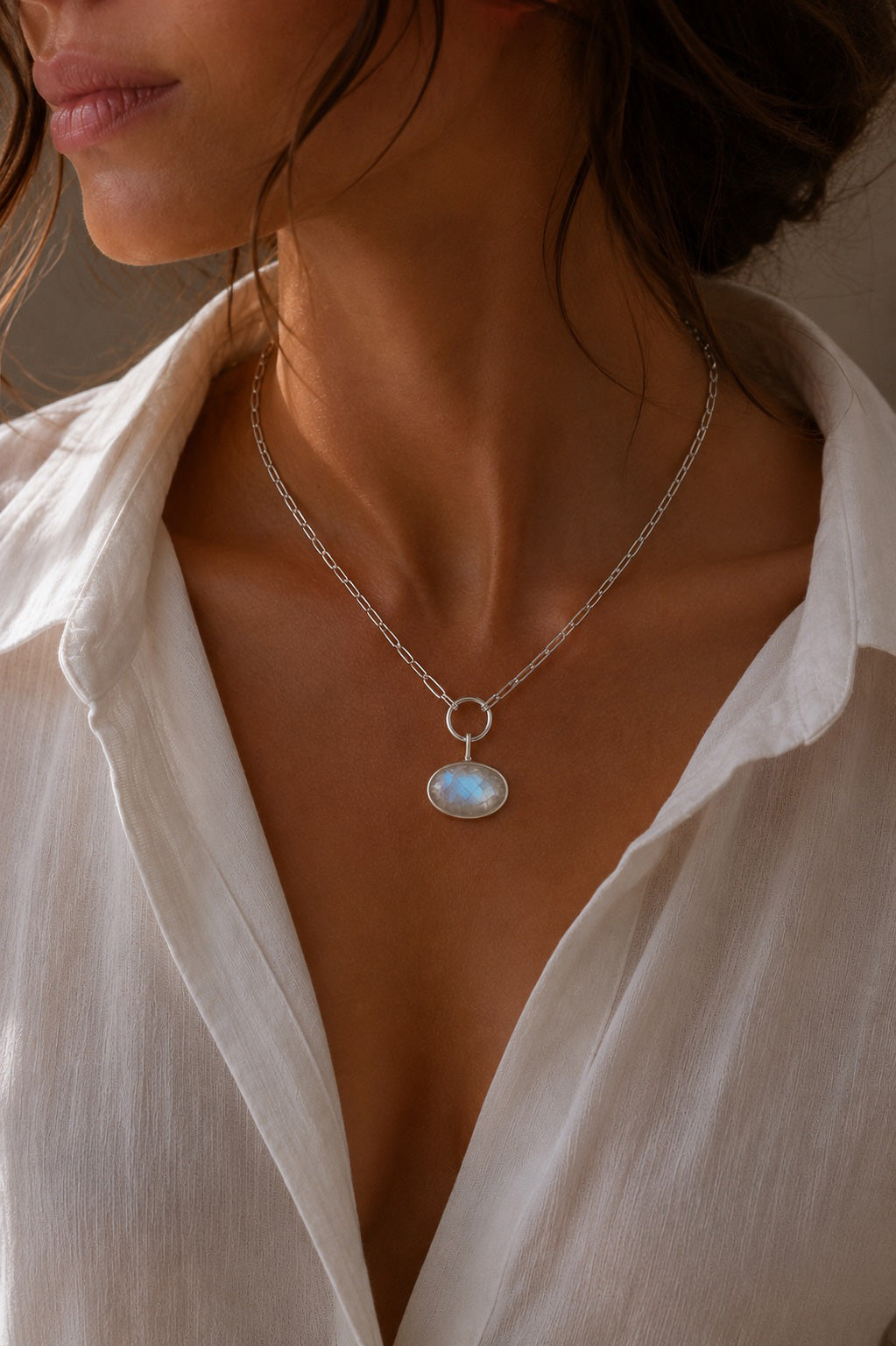 model wearind a paperclip chain with the landscape Oval shaped Unyezi Moonstone pendant by Rya Atelier. Faceted Rainbow Moonstone set in solid 925 sterling silver. 