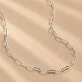 handcrafted solid 925 Sterling Silver paperclip chain necklace on a beige background