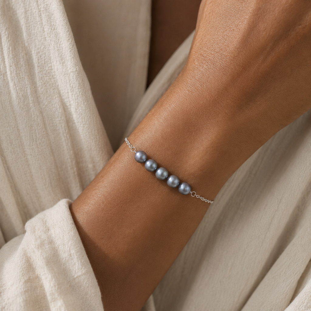 Model wearing the Vivienne Blue Pearl Bracelet by Ryã Atelier, featuring five blue- toned natural freshwater pearls on a delicate 925 sterling silver chain. Individually made in South Africa.