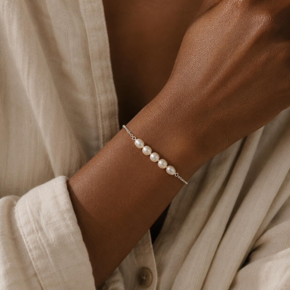 Model wearing The Vivienne Bracelet with five white freshwater pearls on a delicate sterling silver chain by Ryã Atelier
